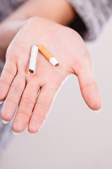 Closeup of broken cigarette on male hand.