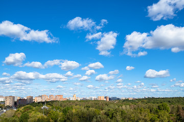 Fototapeta na wymiar blue sky with many white clouds over park and city
