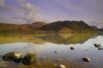 view of ullswater lake facing mountains with a small formation