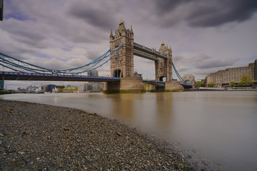 a view of tower bridge of London with cloudy dark sky in the background
