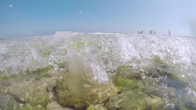 Wave breaking on camera shot in slow-motion, shooting from the shore