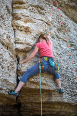 Photo of athlete girl clambering over rock