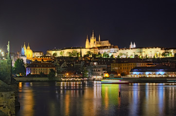 Fototapeta na wymiar Summer night view of old Prague. Vltava river, Charles Bridge with illumination and Prague Castle with amazing Saint Vitus Cathedral. Prague, Czech Republic