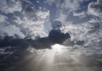 Awesome sky with scattered clouds and sun rays at dawn