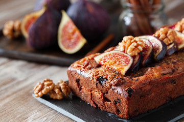 Homemade delicious fig cake with nuts on rustic wooden background