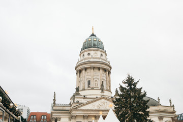 Obraz premium French Cathedral or Franzoesischer Dom in Berlin, Germany. Decorated Christmas tree near by. Celebrating Christmas or New Year.