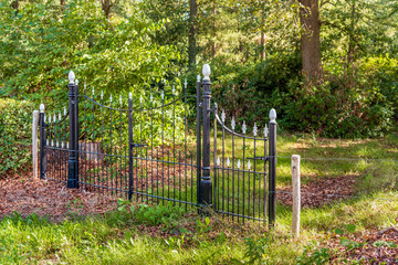 Black painted wrought-iron gate in a park
