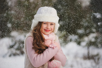 little happy beautiful girl in winter forest