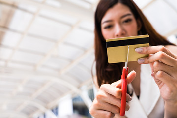 Female hands cutting credit card with scissors.