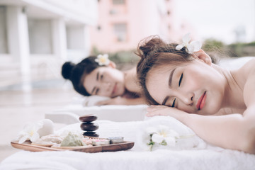 Obraz na płótnie Canvas Beautiful couple woman relaxing massage treatment at beauty spa. Young happy asian girl relaxing in spa salon. Spa massage therapy healing medicine and health care concept.