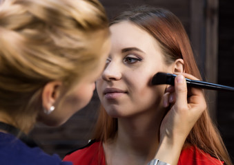 makeup artist preparing young beautiful woman. close-up eyeliner