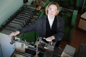 Young woman engineer working at machine tool