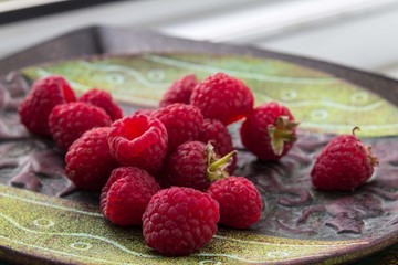 Beautiful dish with a set of fresh fruits: raspberries, grapes