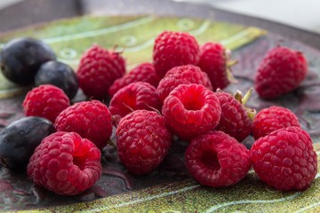 Beautiful dish with a set of fresh fruits: raspberries, grapes