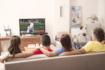 family watching television  together at home