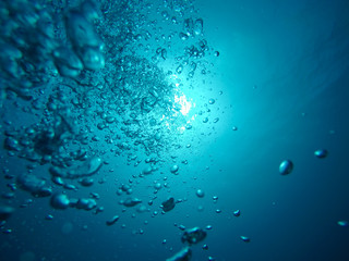 Air Bubbles Going to the Surface and Towards the Sun in a Blue Sea