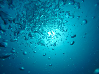Air Bubbles Going to the Surface and Towards the Sun in a Blue Sea