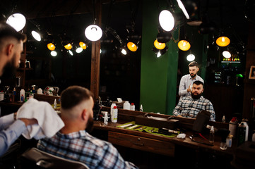 Obraz na płótnie Canvas Handsome bearded man at the barbershop, barber at work.