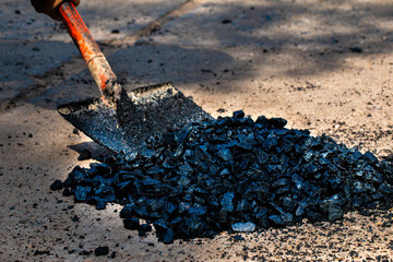 The man is repairing the entrance to the public road.