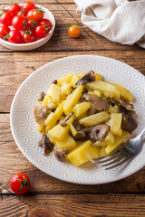 Fried potatoes with mushrooms and onions. Wooden table