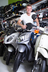 Fototapeta na wymiar Portrait of young smiling male with the motorbike