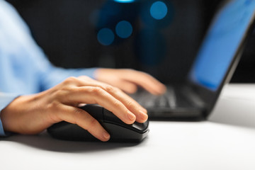 business, education, people and technology concept - close up of female hand with laptop and computer mouse on table