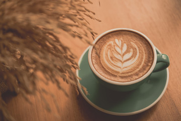 Hot art Latte Coffee in a cup on wooden table and morning light
