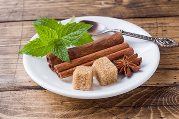 Mint and brown sugar, cinnamon in a plate on a wooden table