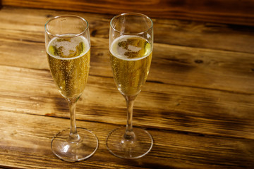 Two glasses of champagne on wooden table