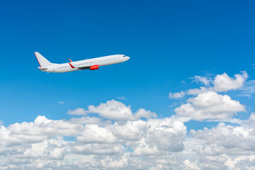 Naklejka na ściany i meble Airplane flying in the blue sky with cloud as the scene