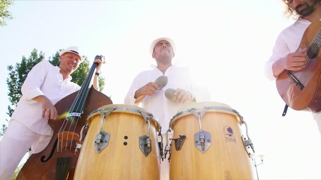 Trio of musicians give street concert in the city at sunset. Live camera. Slow motion
