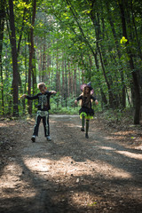 Brother and sister play zombies in forest at halloween