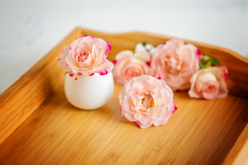 Obraz na płótnie Canvas pink roses on a wooden tray