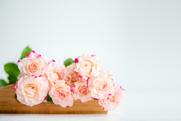 pink roses on a wooden tray