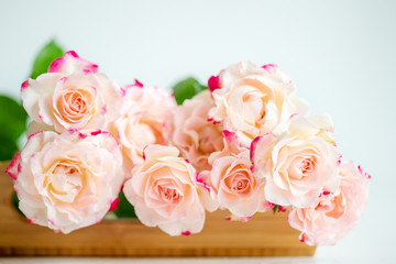 Obraz na płótnie Canvas pink roses on a wooden tray