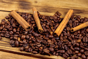 Coffee beans and cinnamon sticks on rustic wooden background