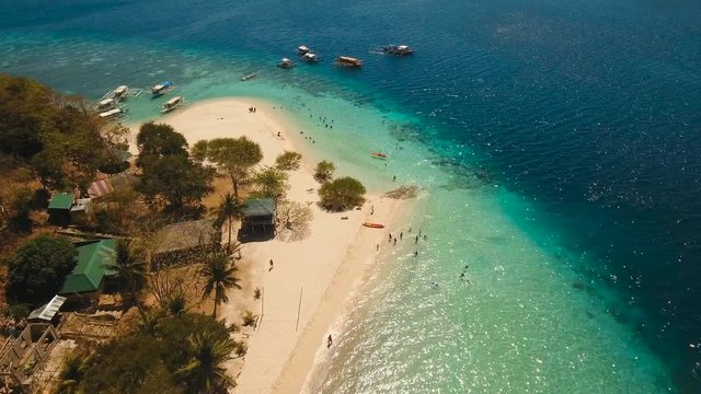 aerial footage tropical island with sand beach and palm trees in blue lagoon with coral reef. Banana island Palawan, Philippines. lagoon with turquoise water seascape Travel concept Aerial video
