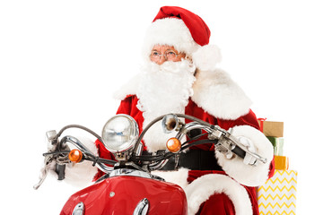 santa claus riding vintage red scooter with gift boxes and looking away isolated on white