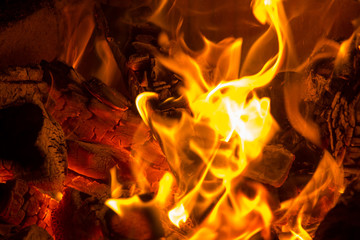 Burning firewood and charcoal in flames in the fireplace