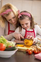 Mother and daughter cutting vegetables