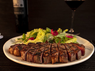 carne acompnañada con vino y ensalada