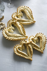 Pane tipico della sardegna detto coccoi preparato a festa a forma di cuore su sfondo blu