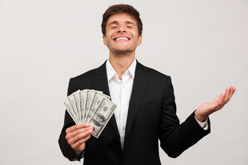 Businessman standing isolated holding money.