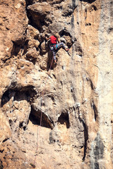 A woman climbs the rock.