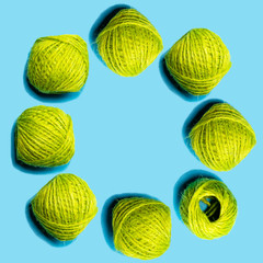 水色背景の上に置いた円形の黄緑の麻糸
