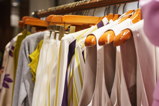 Fashionable women's clothing on wooden hangers in a modern clothing store. 