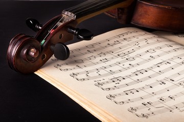 Naklejka premium Close-up of a Violin Pegbox and Sheet Music