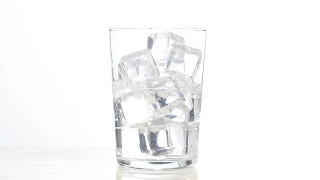 Vertiendo agua en un vaso con hielos