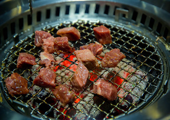 Beef slice grilled on yakiniku stove which has hot charcoal. Barbecue Japanese style. image for background, copy space and backdrop.