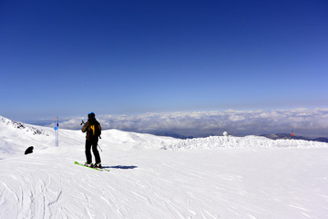 Fototapeta na wymiar On the snow-capped peaks of the mountain Sierra Nevada skiers and snowboarders
